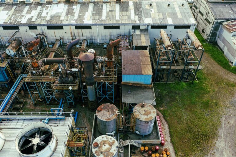 Drone view of industrial area with barrels for petroleum products and pipes connected with warehouses